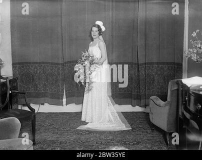 Fille américaine à présenter à la cour . Mlle Hannah Locke de Philadelphie , fille de Mme Robert W Locke , qui fait partie des filles américaines présentées à la Cour par Mme Ray Atherton , épouse de la charge américaine d' Affaires . Elle est photographiée dans sa robe avant de partir pour assister à la première présentation de la Cour à laquelle elle a fait son arc à la Reine , le Roi n'a pas pu être présent à cause du rhumatisme . Miss Locke ' s robe était de dentelle blanche avec une ceinture bleu mat et des bretelles de taffetas , porté avec un train de dentelle blanche . Son bouquet était d'orchidées et de lys blancs Banque D'Images