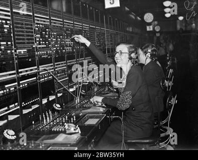 Le Princeof Wales parle en espagnol avec un opérateur téléphonique . Lorsque le Prince de Galles a inspecté le grand nouveau centre téléphonique mondial du bâtiment Faraday à Londres, il a parlé en espagnol avec l'un des opérateurs de standard , qui sont tous des linguistes experts . L'opérateur était Mlle Marion Hart. Le prince passait son standard quand il l'a entendue parler en espagnol . Quand elle avait traité l'appel, il a bavardé avec elle dans la même langue , avec laquelle il s'est familiarisé lors de ses voyages en Amérique du Sud . Photos ; Mlle Marion Hart au standard de Buenos Aires aujourd'hui . SH Banque D'Images