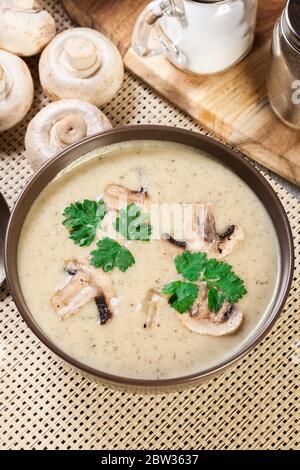 Soupe de crème aux champignons avec herbes et épices dans un bol brun Banque D'Images