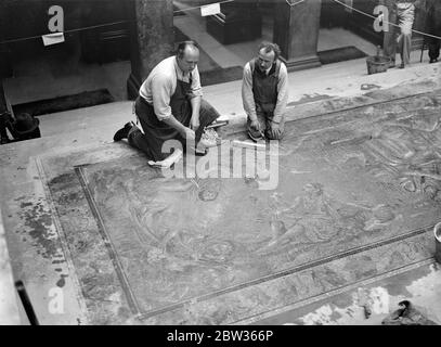 Personnalités célèbres de la société ou de la scène , dont Mme Bryan Guinness , Mlle Virginia Woolf , Mlle Greta Garbo , M. Osbert Sitwell , Et d'autres , ont eu leurs caractéristiques perpétuées dans les mosaïques par M. Boris Anrep , le célèbre artiste qui est responsable des dessins de mosaïque sur les planchers de certains des bâtiments les plus célèbres de Londres . Le travail , maintenant presque achevé , couvre un grand espace au sol de la National Gallery , Londres . Les caractéristiques sont facilement reconnaissables . Toutes les personnalités représentées sont des amis personnels de l'artiste . M. Boris Anrep ( à gauche ) avec un assistant au travail sur les mosaïques de l' Banque D'Images