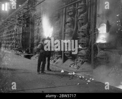 Le travail le plus chaud dans un Londres qui frisson . Alors que la plupart des Londoniens ont frisseté le temps froid des vignobles , cet homme de la Beckton Works of the Gas , Light and Coke Company a balanci dans la chaleur . Il est photographié par l'éblouissement du four lorsqu'il décharge une riposte . 4 décembre 1933 Banque D'Images