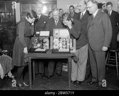 Postmaster général présente le téléphone de la première école à Eltham - 160 à être équipé . Sir Kingsley Wood , le maître de poste général , a présenté le premier poste téléphonique de l'école au directeur de l'école centrale d'Eltham , Well Hall , Eltham . Au total, 160 de ces ensembles , qui sont utilisés à des fins de démonstration , seront distribués à diverses écoles . Expositions de photos ; Sir Kingsley Wood observer deux élèves faire fonctionner le nouveau téléphone à l'école centrale d'Eltham. 7 décembre 1933 Banque D'Images