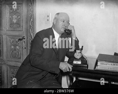 Le général de poste de l'Amérique paie la visite aérienne à Londres , et téléphone l'Amérique . M. James Farley , le ministre des postes des États-Unis a survolé de Paris à Londres lors d'une visite aérienne d'une journée . Il a l'intention de revenir demain . M. Farley doit inspecter certains des arrangements postaux britanniques , dans le but de réduire le déficit de fonctionnement du service postal des États-Unis . M. James Farley , appelant l'Amérique à son hôtel de Londres . 15 décembre 1933 Banque D'Images