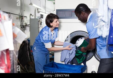 L'accent africain avec sa femme sous-vêtements sales de tri et mettre en machine à laver de la blanchisserie Banque D'Images