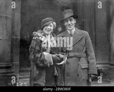 Célèbres comédiens au principal ' s enregistrer bureau mariage au docteur . Eh bien - les comédiens connus ont formé une garde d'honneur quand Mlle Eve Benson , qui est la princesse des coeurs dans ' Reine des coeurs ' , la pantomine de Lyceum , a été mariée au bureau d'enregistrement de Paddington , Londres , au Dr Albert Heming de Birmingham . Le Dr Heming et sa mariée se sont rencontrés il y a deux ans à Dorset , où l'actrice a passé des vacances de caravane . Photos ; la mariée et le marié quittant le bureau de caisse . 30 décembre 1933 Banque D'Images