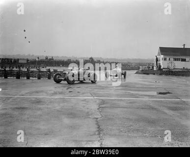 Whitney Straight remporte une course internationale sur piste à Brooklands avec une vitesse moyenne de 90 miles par heure . M. Whitney Straight , le jeune pilote millionnaire , a remporté la course internationale de Trophée sur le circuit de Brooklands, sur le parcours de 250 miles à Weybridge , Surrey , auquel ont participé tous les pilotes crack English . Photos ; l'honorable Brian Lewis , dirigeant Whitney Straight sur l'un des coins . Les deux ont conduit des voitures Maserati . 28 mars 1933 Banque D'Images