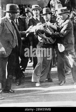 Plus d'un millier d'arrestations à Paris contre les émeutes de réduction des salaires - la police dans des batailles féroces avec des manifestants . Un manifestant arrêté qui lutte pour se libérer sur le boulevard Haussmann . 20 juillet 1935 Banque D'Images