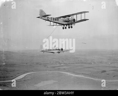 Sir Alan Cobham a fait un essai de ravitaillement en vol à mi-vol à Portsmouth en préparation de son vol non-stop vers l'Inde le 21 septembre. Son avion , un ' Airspeed Courier ' est un monoplan équipé d'un moteur Armstrong Siddeley ' Lynx ' de 240 HP , et le ravitaillement a été effectué par un avion à double engine , qui a été utilisé comme un pétrolier . Il sera accompagné, lors de son vol en Inde, par le chef de l'escadron W Helmore , qui a obtenu un congé spécial du ministère de l'Air pour le vol . Le ravitaillement sera effectué en route par un transporteur de troupes « Victoria » à l'aéroport d'Alexandra et un « Valencia » à Shaib Banque D'Images