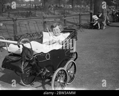 Tommy Sopwith ' s grand effort , une course de son propre dans la Serpentine . Little Tommy Soopwith , fils de 22 mois de M. et de Mme Tom Soopwith , sur qui l'attention du monde entier est concentrée lorsqu'ils défient la tenue de l'Amérique sur la coupe de l'Amérique , le trophée de yachting le plus célèbre du monde , Passé dimanche après-midi au Serpentine à Hyde Park à voile son yacht modèle , qu'il a nommé l' ' Endeavour '. Il espère être un yachtsman comme son papa . Photos montre , Little Tommy Sopwith avec son yacht modèle dans son pram à Hyde Park . 16 septembre 1934 Banque D'Images