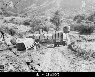 La route d'Adigrat à Makale , l'objectif suivant de l'armée italienne , dans les terrains les plus difficiles que les envahisseurs ont encore rencontrés . Les gros camions de transport qui se déplacent vers le haut hommes et les fournitures doivent être orientés autour de 1500 virages en épingle à cheveux . La route , un peu plus qu'une voie ne permet qu'un seul sens de la circulation , et tout véhicule qui tombe l'un des nombreux dangereux est abandonné , car il est inutile de tenter de le remettre sur la route . Jusqu'à présent, 17 véhicules ont été brisés . Photos , camions de transport italiens sur la route dangereuse à Makale . Le camion de gauche est tombé Banque D'Images