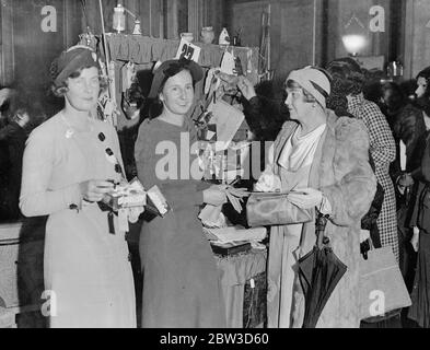 Dorothy Round et Molly Gourlay comme détenteurs de stalle sur le marché de produits de Londres . Mlle Dorothy Round vend une paire de gants à une cliente à son stand . Sur la gauche se trouve Mlle Molly Gourlay . 21 novembre 1935 Banque D'Images