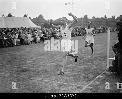 Les athlètes lycéens de Paris rencontrent l'équipe de Londres pour la première fois à l'école Rutlish , Merton , Londres . Photos , W W G Foster de l'école du comté de Harrow gagnant la course de miles avec P J Foster ( Mill Hill ) second . . 26 juillet 1935 Banque D'Images