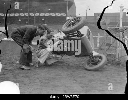 West Ham speedway pour présenter les courses de voitures midget . Brooklands porte-disque conçoit nouveau bébé . La photo montre M. G B Bush levant sa voiture intermédiaire d'une main pour faire un réglage à West Ham regardé par Harold ( Tiger ) Stevenson . 20 juin 1935 Banque D'Images