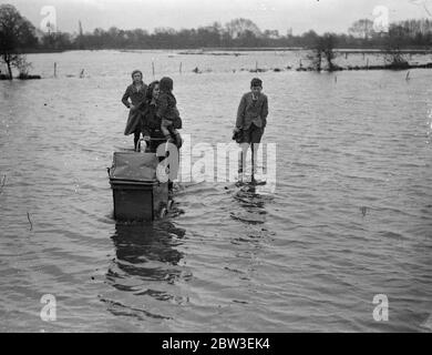 Inondations dans le Berkshire . Une mère avec un bébé et un bébé et d'autres marchant dans l'eau d'inondation près de Reading . 30 décembre 1934 Banque D'Images