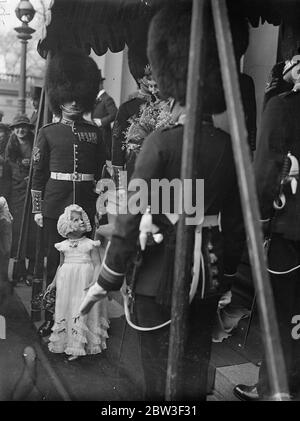 Autres invités à un mariage à Londres ! . Le mariage de M. Gerald E W Potter , Grenadier Guards et Miss Virginia Stuart Reynolds a eu lieu à la Chapelle militaire royale , caserne Wellington . La photo montre une petite demoiselle d'honneur regardant vers le haut un haut membre de la garde d'honneur . 5 mars 1936 Banque D'Images