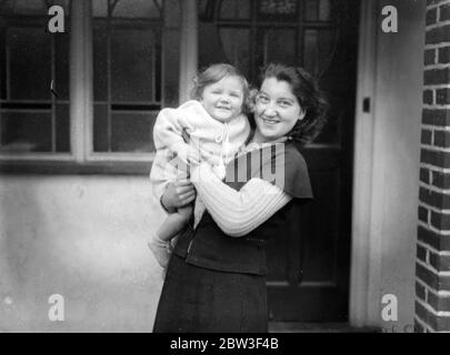 Nursemaid sauve bébé de la maison blasing à St Albans . La maison de l'automobiliste en flammes . Janet Outlaw , fille de 16 mois de M. et Mme R S Outlaw , de Rayon d' ou Redbourn , près de St Albans , a été secourue par Mlle Elsie Walker , infirmière de 21 ans, quand la maison a été renvoyée par le feu . Mlle Walker a couru un escalier flamboyant jusqu'à la pépinière où Janet dormait. Quand elle a apporté le bébé dehors ses cheveux était sur le feu . Beaucoup de précieuses photos ont été détruites et les dommages sont estimés à plusieurs milliers de livres. Photos de Miss Elsie Walker avec Janet Outlaw, 16 mois, fille Banque D'Images