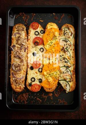 Composition de délicieux sandwichs chauds avec différentes garnitures. Fromage, thon, mozarella, épices Banque D'Images