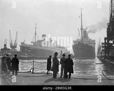 Ancien et nouveau navire amiral de la Cunard White Star Fleet se réunit à Southampton . Les anciens et nouveaux navires de la flotte Cunard White Star se sont réunis à Southampton lorsque la Berengaria , de retour d'Amérique, a amarré le long du navire géant Queen Mary dans l'Ocean Dock . Le Commodore Sir Edgar Britten , qui doit commander la reine Mary , était auparavant sous le commandement de la Berengaria . Spectacles photo , Berengaria amarré le long de la reine Mary à Southampton . 10 avril 1936 Banque D'Images