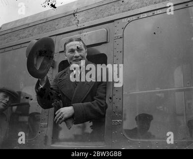 Tommy Loughran , ancien détenteur américain du championnat du monde de boxe poids lourd léger , a quitté Waterloo sur le train de bateau Aquitania pour retourner aux États-Unis . Photos , Tommy Loughran signe au revoir alors qu'il quittait Waterloo . 8 avril 1936 Banque D'Images