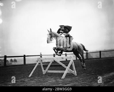 Répétition de cavalerie pour le tournoi Royal . Déselle leurs montages sur des sauts à couper le souffle et de réaliser les plus difficiles exploits avec de superbes chevaux , les troopers de l'école d'équitation à Weedon , Northamptonshire , sont réhéasring pour le tournoi Royal , qui s'ouvre à Olympia le mois prochain . Les hommes qui y participent sont choisis des unités de cavalerie de l'Armée britannique . Photos montre , trooper prend un saut sans l'aide de l'étrier ou de la rein . 14 avril 1936 Banque D'Images