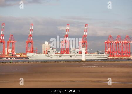 Ville de Liverpool, Angleterre. Le HMS Queen Elizabeth passe devant les grues rouges du terminal de conteneurs de Liverpool, sur la rivière Mersey. Banque D'Images