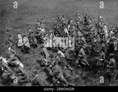 Sept cent cinquante Croix Rouge , VAD ' s participent à des exercices anti - gaz près de Winchester . Photos montre , infirmières , avec des masques à gaz qui se précipitent dans un champ pendant une attaque à gaz . 21 mai 1935 Banque D'Images