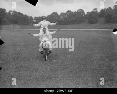 Ils gardent leur équilibre ! . Jessie Hole , dont l'idée de la maison est deux roues séparées par un moteur , se trouve à l'aise sur les barres de poignée , comme son frère , George Hole , tente un peu acrobatique moto à cheval au Crystal Palace , Londres . 12 juillet 1936 Banque D'Images