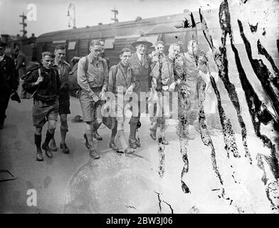 25 écoliers partent sur la reine Mary pour un trek à travers les montagnes canadiennes . Une fête de 25 garçons de l' école moderne de Leeds ' Boys ' accompagnée du Maître en chef , Dr G F Morton , à gauche de la gare de Waterloo sur le train de bateau ' Queen Mary ' pour New York , D'où la fête se fera au Canada pour une aventure de trekking à travers les Laurentides . Photos , les écoliers de Leeds au départ de Waterloo . 22 juillet 1936 Banque D'Images