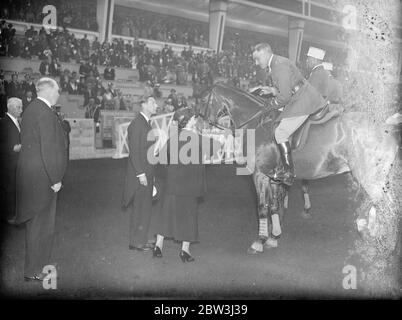 La duchesse de York présente des Rosettes à l'équipe française victorieuse au spectacle international de chevaux . La duchesse de York , accompagnée du duc et des princesses , a présenté des rosettes à l'équipe française victorieuse qui a remporté la coupe du Prince Édouard de Galles Gold Challenge dans le concours de saut au salon International du Cheval , Olympia . Des spectacles de photos , la duchesse de York , accompagnée du duc , présentant des rosettes à l'équipe française gagnante à Olympia . 4 juin 1936 Banque D'Images