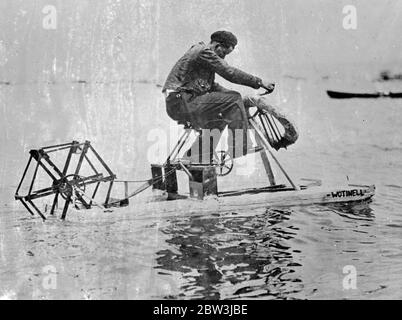 Seulement UN Cast - Off Bicycle et 80 cents - mais il s'est construit LUI-même UNE vitesse - bateau Robert Simpson , 18 - année - mécanicien de San Rafael , Californie , Etats-Unis n'avait que 80 cents ( environ 16 shillings ) et un Cast - Off Bicycle . Mais avec beaucoup d'insinuity il a réussi à produire une vitesse miniature - bateau . Monter le cadre de vélo sur une paire de flotteurs il a conduit une palette brute , fixée à la poupe , au moyen de la chaîne et de la roue dentée . Photos : Robert Simpson teste son particulier , maison - vitesse faite - bateau . [ 1936 ] Banque D'Images