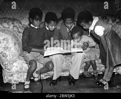 Les enfants du ministre Abyssinian étudient la scène de l'invasion italienne . Joe Martin , fils de 23 ans d'Asaj C Martin , ministre éthiopien à Londres , montrant ses frères et sœurs , le théâtre de l'attaque italienne sur leur pays , sur une carte de la Lgaison Abyssinienne à Londres . De gauche à droite - Charles , Jean , Joseph , David et Léa . 3 octobre 1935 Banque D'Images