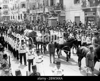 Roi Fuad d'Égypte enterré au Caire . Les foules denses s'emparont sur un parcours de huit kilomètres . Porté sur une voiture de canon tirée par six chevaux noirs magnifiques à travers cinq miles de rues densément remplies , le corps du roi Fuad d'Égypte a été pris avec impressionnante pompe orientale du palais Abdin , la résidence officielle , À la mosquée Rifai pour l'enterrement dans le mausaleum qu'il s'est préparé pour lui-même il y a des années . Pendant que le cortège déménage , mené par le corps de chameau , des fusils de 21 minutes sonnaient des casernes et des avions de l'armée de l'air égyptienne rôdirent au-dessus . Prince Mohammed Ali , présomptif héritier avec des membres de la famille royale Banque D'Images