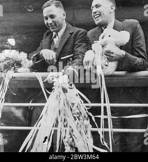 Les athlètes olympiques australiens Sail de Sydney pour les Jeux de Berlin les membres des équipes olympiques d'Australie et de Nouvelle Zélande qui ont participé aux Jeux olympiques de cette année à Berlin ont eu un envoi royal - lorsqu'ils ont quitté Sydney , les nouveaux Weles du Sud , sur le paquebot de Mongolie . Des milliers ont applaudi sur la coquee alors que le paquebot , festooné avec des banderoles , s'est déplacé . Expositions de photos : H . F . Turner ( à gauche ) , le sculpteur australien , et W . G . Croix , rameur australien , avec une mascotte et un petit pain de banderoles à leur départ de Sydney . 2 juin 1936 Banque D'Images