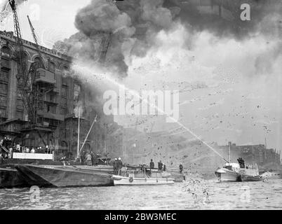 Les flotteurs de feu combattent le grand entrepôt de thé, qui menace le dockland de Londres . Combattre les flammes du feu flotte sur la Tamise . 25 septembre 1935 Banque D'Images