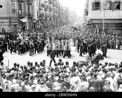 Roi Fuad d'Égypte enterré au Caire . Les foules denses s'emparont sur un parcours de huit kilomètres . Porté sur une voiture de canon tirée par six chevaux noirs magnifiques à travers cinq miles de rues densément remplies , le corps du roi Fuad d'Égypte a été pris avec impressionnante pompe orientale du palais Abdin , la résidence officielle , À la mosquée Rifai pour l'enterrement dans le mausaleum qu'il s'est préparé pour lui-même il y a des années . Pendant que le cortège déménage , mené par le corps de chameau , des fusils de 21 minutes sonnaient des casernes et des avions de l'armée de l'air égyptienne rôdirent au-dessus . Prince Mohammed Ali , présomptif héritier avec des membres de la famille royale Banque D'Images