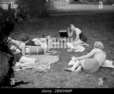 Musique de la rivière Sunny . Bien que les Londoniens aient manqué le soleil , les vacanciers du week-end le long des hauts tronçons de la rivière ont été plus chanceux . Les parties de rivière , la plupart des membres en maillots de bain , se prélasser au soleil ou ont tenu des réunions sportives impromptues au bord de la rivière . Photos : UNE fête de fin de semaine fraîche passe le dimanche après-midi ensoleillé avec des gramophones le long de la rive de la rivière entre Sunbury et Walton . 5 juillet 1936 Banque D'Images