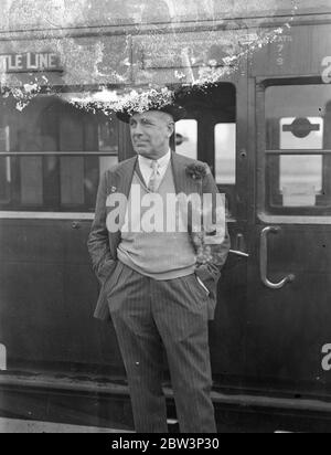 Earl Howe part pour participer au Grand Prix d'Afrique du Sud . Earl Howe , le pilote de course britannique , a quitté Waterloo sur le train de bateau du château de Warwick pour l'Afrique du Sud , où avec un certain nombre d'autres pilotes anglais , il doit participer au Grand Prix le jour du nouvel an . Photos montre , Earl Howe parlant à un fonctionnaire du chemin de fer alors qu'il quittait Waterloo . 29 novembre 1935 1936 Banque D'Images