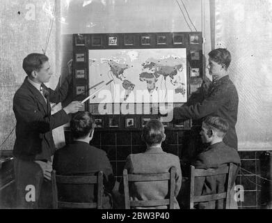 London Schoolboy ' plug in ' à la géographie, la carte elecctric faite maison les fait apprendre et comme elle . Les élèves de l'école centrale de Brockley , Londres maintenant ' plug in ' à des leçons de géographie . M. W T Harrison , maître de géographie à l'école, assisté par les maîtres d'art et de menuiserie et les garçons de la sixième forme , a construit une carte électrique . Quand un garçon est interrogé sur n'importe quelle partie du monde , il répond en insérant une fiche dans une des cent prises , une lumière brille derrière une diapositive en verre marquée de la température , des précipitations et des produits principaux de la région . Si le garçon utilise la mauvaise prise , t Banque D'Images