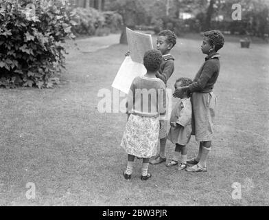 Les enfants du ministre Abyssinien lisent les dernières nouvelles de crise . Quatre enfants du Dr Martin , ministre Abyssinien à Londres , lisant les dernières nouvelles du différend de leur pays avec l'Italie au motif de la légation abyssinienne . 20 juillet 1935 Banque D'Images