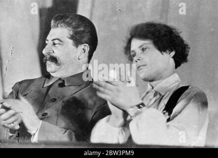 Le chef sourit , applaudissements de ses disciples . Jospeh Staline , dictateur virtuel de la Russie soviétique et idole de millions de travailleurs , sourit tranquillement en applaudissant avec Mlle Maria Demchenko , l'un de ses disciples les plus ardents , lors du dixième Congrès de la Ligue des jeunes communistes au Kremlin à Moscou . Maria est célèbre dans toute l'Union soviétique pour une promesse qu'elle a faite à Staline . Elle a donné son mot qu'en 1935 elle moissonnerait une récolte record sur la ferme collective de betterave à sucre sur laquelle elle est employée . À l'automne de cette année-là, elle avait fait son travail et a commencé à faire son travail Banque D'Images
