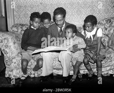 Les enfants du ministre Abyssinian étudient la scène de l'invasion italienne . Joe Martin , fils de 23 ans d'Asaj C Martin , ministre éthiopien à Londres , montrant ses frères et sœurs , le théâtre de l'attaque italienne sur leur pays , sur une carte de la Lgaison Abyssinienne à Londres . De gauche à droite - Charles , Jean , Joseph , David et Léa . 3 octobre 1935 Banque D'Images