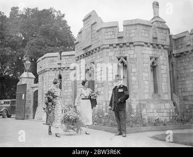 Gardien de pavillon du roi qui fabrique 64 sortes de vin au spectacle floral du château de Windsor , terrain privé ouvert au public . Avec la permission du Roi , la partie entièrement privée du parc du Château de Windsor a été utilisée pour la 42e exposition annuelle de roses et de fleurs de la Société agricole de Windsor , Eton et District . le Roi , un amateur enthousiaste gardner , est le patron de la société . C'est le seul jour de l'année où cette partie des motifs nous est ouverte au public . Le roi a donné une coupe de défi pour les pois doux . Photos spectacles , concurrents passant le South Western Lodge de Windsor cas Banque D'Images