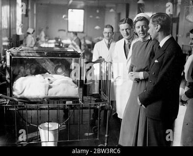 Le duc de York voit une tente à oxygène salvant la vie à l' hôpital pour enfants de la Reine . Le duc de York a visité les quartiers et a attraillé plusieurs enfants lorsqu'il a visité l'hôpital pour enfants de la Reine à Hackney Road , pour présider la Cour des gouverneurs annuelle . Photos , le duc de York , intéressé par William Payne , un bébé de six mois , qui, souffrant de pneumonie broncho , est dans la tente d'oxygène de l'hôpital depuis dix jours . 29 avril 1936 Banque D'Images