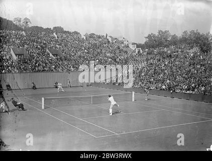 Gottfried Von Cramm bat Fred Perry , détenteur en finale du championnat de France . Fred Perry , le détenteur , a perdu le camslde France au Stade Roland Garros , Paris , à son ancien rival , le joueur de premier plan de l' Allemagne , Baron Gottfried vo Cramm , qui l'a battu 6 - 0 , 2 - 6 , 6 - 2 , 2 - 6 , 6 - 0 . Photos , une vue générale de Perry , contre von Cramm titre match . Fred Perry a son dos à la caméra . 2 juin 1936 Banque D'Images