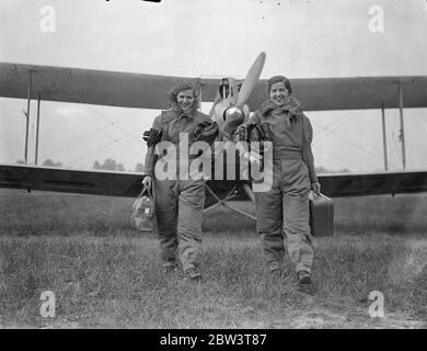 Les sœurs comptete contre les as à Londres à l'île de Man air course . Deux sœurs , Miss M Glass , pilote , et Miss Shela Glass , navigateur , participent à la course aérienne de Londres à l'île de Man qui a commencé à Henworth . Ils sont en vol une vieille machine de Havilland DH 60 Cirrus Moth entrée par leur mère , Mme M Glass . Les deux sœurs ont appris à voler à Heston il y a deux ans. C'est leur première course . En compétition avec eux sont des pilotes expérimentés de la RAF et des pilotes civils . Photos , Sheila Glass ( à gauche ) et Mabel Glass arrivant avec leurs sacs pour le début . 30 mai 1936 Banque D'Images