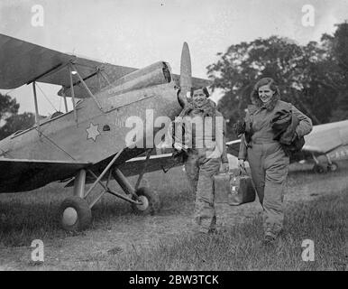 Les sœurs comptete contre les as à Londres à l'île de Man air course . Deux sœurs , Miss M Glass , pilote , et Miss Shela Glass , navigateur , participent à la course aérienne de Londres à l'île de Man qui a commencé à Henworth . Ils sont en vol une vieille machine de Havilland DH 60 Cirrus Moth entrée par leur mère , Mme M Glass . Les deux sœurs ont appris à voler à Heston il y a deux ans. C'est leur première course . En compétition avec eux sont des pilotes expérimentés de la RAF et des pilotes civils . Photos , Sheila Glass ( à gauche ) et Mabel Glass arrivant avec leurs sacs pour le début . 30 mai 1936 Banque D'Images