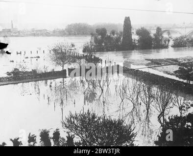 Quatre morts et des centaines de sans-abri dans les inondations désastreuses françaises . Quatre morts et des ravages ont été nombreux par les inondations des fleuves Saone , Rhône , Isers , Drôme , Ardèche et Durance dans l'ouest de la France . La pluie continue de tomber et les eaux augmentent régulièrement . Dans certaines parties de la vallée de la Bhone, la rivière est maintenant de 11 milles de large et 25 pieds de profondeur , battant tous les records d'inondation depuis 1855 . Des centaines de familles ont dû être sauvées . Photos , le plin inondé de Grenges les Valence . 14 novembre 1935 Banque D'Images