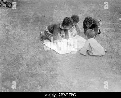 Les enfants du ministre Abyssinien lisent les dernières nouvelles de crise . Quatre enfants du Dr Martin , ministre Abyssinien à Londres , lisant les dernières nouvelles du différend de leur pays avec l'Italie au motif de la légation abyssinienne . 20 juillet 1935 Banque D'Images