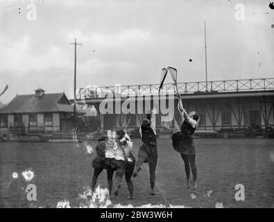 Les femmes joueurs de crosse brave la boue à Paddington . Joueurs qui sautent pour le ballon . Les joueurs gallois portent des tuniques légères . 10 janvier 1936 Banque D'Images