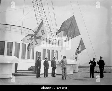 La reine Mary , remise à Cunard White Star à Southampton , vole ses nouveaux drapeaux . Le RMS Queen Mary est maintenant officiellement un Cunard White Star Liner . Les drapeaux de John Brown et de la compagnie les constructeurs de navires , ont été abaissés à bord du navire géant à Southampton et le drapeau de Cunard White Star a hissé à leur place . Photos montre , hissage des drapeaux Cunard White Star et abaissement du drapeau John Browns comme la ' Reine Mary ' a été remise à Southampton . 12 mai 1936 Banque D'Images